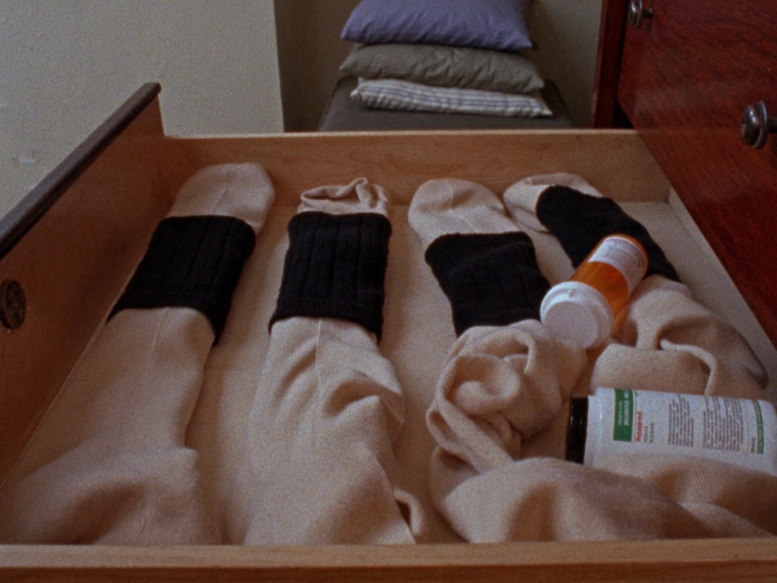 Dresser drawer with compression socks, a pill bottle and magnesium