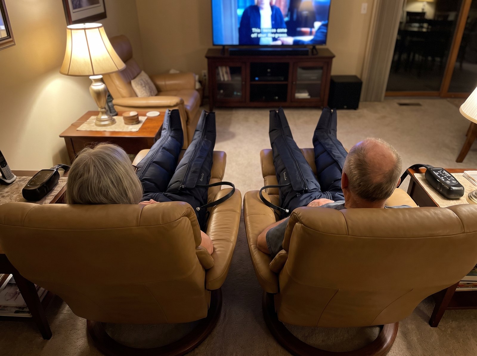 Couple in matching recliners, both wearing Sensia Wave boots